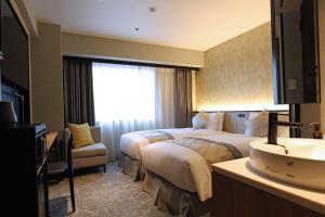una camera d'albergo con due letti e un lavandino di Best Western Plus Nagoya Sakae a Nagoya