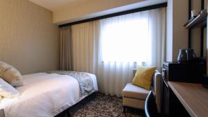 a hotel room with a bed and a window at Best Western Plus Nagoya Sakae in Nagoya