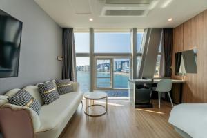 ein Wohnzimmer mit einem Sofa und einem Schreibtisch in der Unterkunft Gray 193 Hotel in Busan