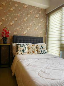 ein Schlafzimmer mit einem Bett mit Blumen an der Wand in der Unterkunft The Metro Haven in Manila