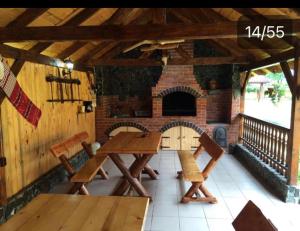 a patio with two tables and a brick fireplace at Pensiunea Bujor de Munte in Cîrţişoara