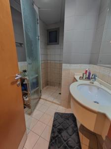 a bathroom with a tub and a sink and a shower at Luxury Corniche Apartment in Sharjah