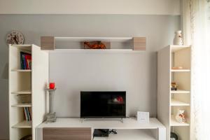 a living room with a tv on a white wall at Jenny's Coastal escape in Nea Kallikrateia