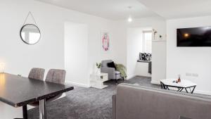 een woonkamer met een eettafel en stoelen bij Stunning flat near the Lake in Gosport