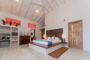 1 dormitorio con 1 cama grande y cabecero de madera en The Divine Villa en Talpe