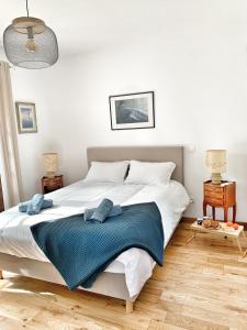 a bedroom with a large white bed with a blue blanket at Villa familiale à Sanary, climatisée, plage à pieds in Sanary-sur-Mer