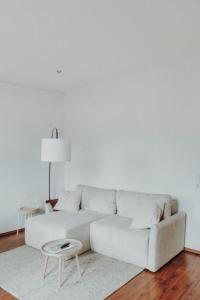 a white living room with a white couch and a table at NEU! Weinstraßenzauber Altbauwohnung mitten in NW in Neustadt an der Weinstraße
