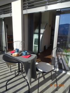 een tafel en stoelen op een balkon met een tafel en stoelen bij Panoramaterrace, Wein & relax in Appiano Sulla Strada Del Vino