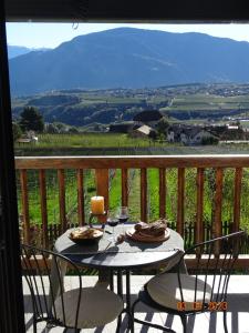 een tafel met eten en wijnglazen op een balkon bij Panoramaterrace, Wein & relax in Appiano Sulla Strada Del Vino
