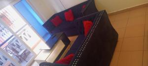 a room with a bed with red pillows at Lovely and spacious apartment with swimming pool in Mtwapa +20 photos