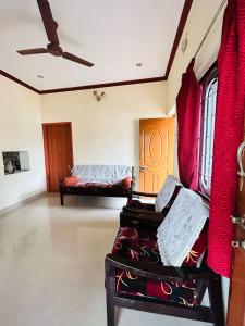 a living room with red curtains and a couch at Sirvachur madhurakalli amman guest house in Perambalūr