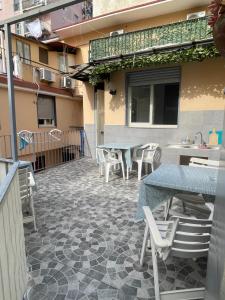un patio con tavoli e sedie in un edificio di DaRoDa Guest House Napoli a Napoli