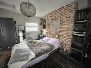 a bed in a room with a brick wall at Town House in the North Laines in Brighton & Hove