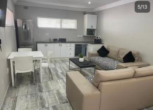 sala de estar y cocina con sofá y mesa en Guest house on Gillian Unit 7 en Ballito