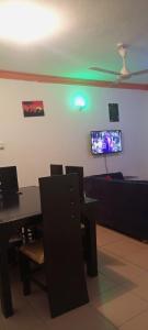 a dining room with a table and a tv on the wall at Lovely and spacious apartment with swimming pool in Mtwapa