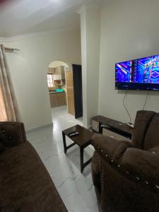 a living room with a couch and a tv on the wall at Imara House in Nairobi