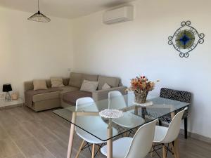 a living room with a glass table and a couch at Logement entier vue mer in Bastia