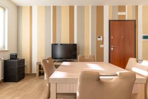 a dining room with a table and a television at Casadamare Salento in Brindisi