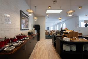 a restaurant with a buffet line with tables and chairs at Milling Hotel Gestus in Aalborg