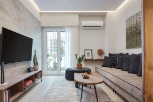uma sala de estar com um sofá e uma televisão em Acropolis Elite Residences em Atenas