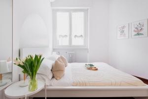 um quarto branco com uma cama e uma mesa em Stylish and Cozy apt close to Naviglio (MUDEC) em Milão