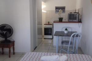 a small kitchen with a table and a microwave at Penedo - Quitinete para temporada in Itatiaia