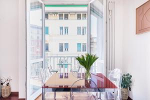 uma sala de jantar com uma mesa e uma grande janela em Stylish and Cozy apt close to Naviglio (MUDEC) em Milão