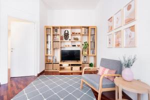 uma sala de estar com uma televisão, uma cadeira e uma mesa em Stylish and Cozy apt close to Naviglio (MUDEC) em Milão