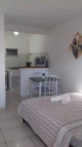 a bedroom with a bed and a table with a microwave at Penedo - Quitinete para temporada in Itatiaia