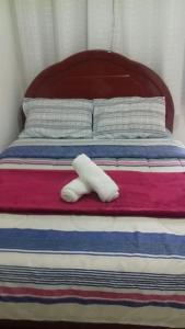 a white towel sitting on top of a bed at Penedo - Quitinete para temporada in Itatiaia