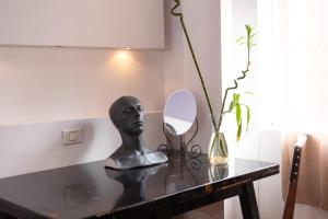 una mesa con un busto y un espejo en ella en sharing retro vintage luxury apartment en Bucarest