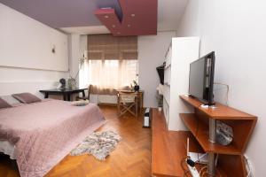 1 dormitorio con 1 cama y TV de pantalla plana en sharing retro vintage luxury apartment, en Bucarest