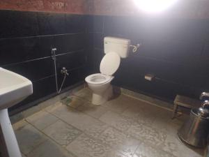 uma casa de banho com um WC e um lavatório em Konkan Nest Resort em Ganpatipule