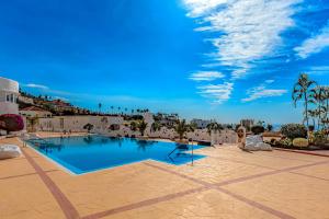 a large swimming pool in the middle of a patio at Villa Las Mimosas in Adeje