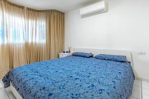 a bedroom with a blue bed and a window at Villa Las Mimosas in Adeje