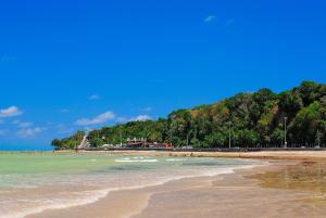 a beach with a bunch of people in the water at Setai Yacht Premium - By Almare Flats in João Pessoa
