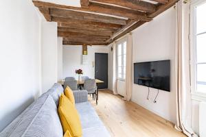 un soggiorno con divano e TV di Appartement Quartier Fontaine Chatelet Les Halles Free Netflix a Parigi