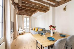 una sala da pranzo con tavolo e divano di Appartement Quartier Fontaine Chatelet Les Halles Free Netflix a Parigi