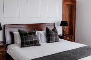 a bedroom with a bed with a wooden headboard and pillows at Fritz Manor Bed and Breakfast in Swakopmund