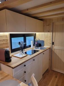a small kitchen with a sink and a window at Unwind Cabin Heisterberg in Driedorf