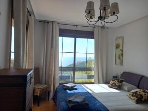 a bedroom with a bed and a large window at Olivos Holiday Home in Altea