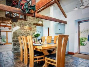 a dining room with a wooden table and chairs at Stunning Coastal Barn Conversion in Kingsbridge