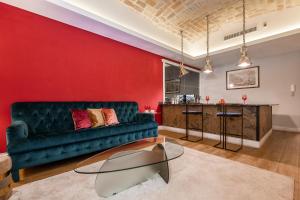 - un salon avec un canapé vert et un mur rouge dans l'établissement HT LA CASA DEI SOGNI, à Rome