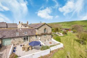 an aerial view of a large stone house with a yard at Stunning Coastal Barn Conversion in Kingsbridge