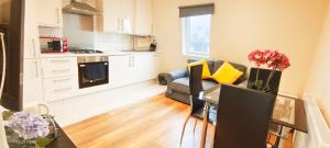 a kitchen and living room with a couch and a table at Tulip 5 Top Floor at Hammersmith in London