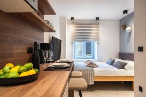 Un dormitorio con una cama y una mesa con un bol de fruta en Arta Apartments City Center - with Private Parking en Pula
