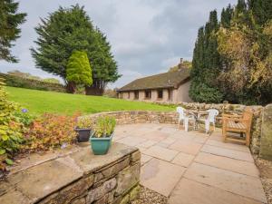 a patio with a table and chairs and a stone wall at 1 Bed in Alston SZ499 in Leadgate