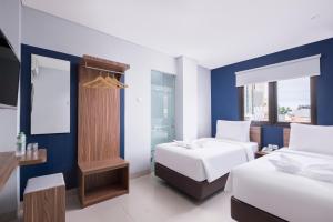a hotel room with two beds and a window at Gold Hotel Simpang Lima in Semarang