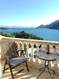 een stoel en een tafel op een balkon met uitzicht op het water bij Apartments Laura Mljet in Sobra