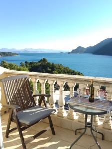 a chair and table on a balcony with a view of the water at Apartments Laura Mljet in Sobra +27 photos